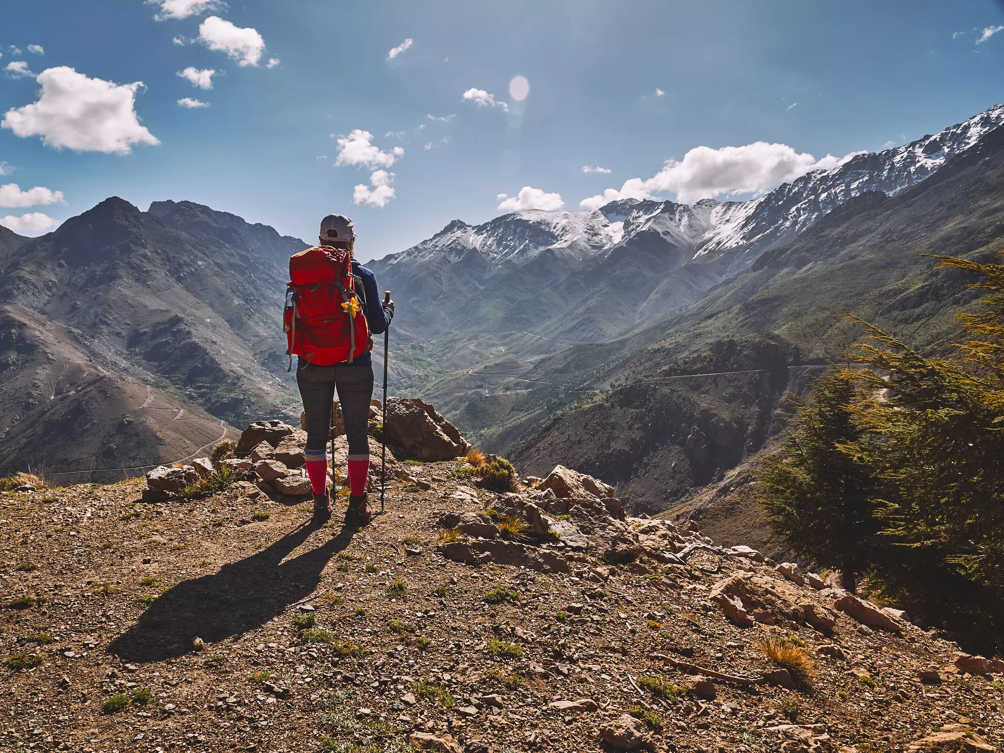 A hiker looking at snow covered peaks in the High Atlas mountains in Morocco.