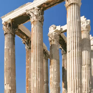 Colonnade of the Temple of Olympian Zeus in Athens on a sunny day with clear blue skies.