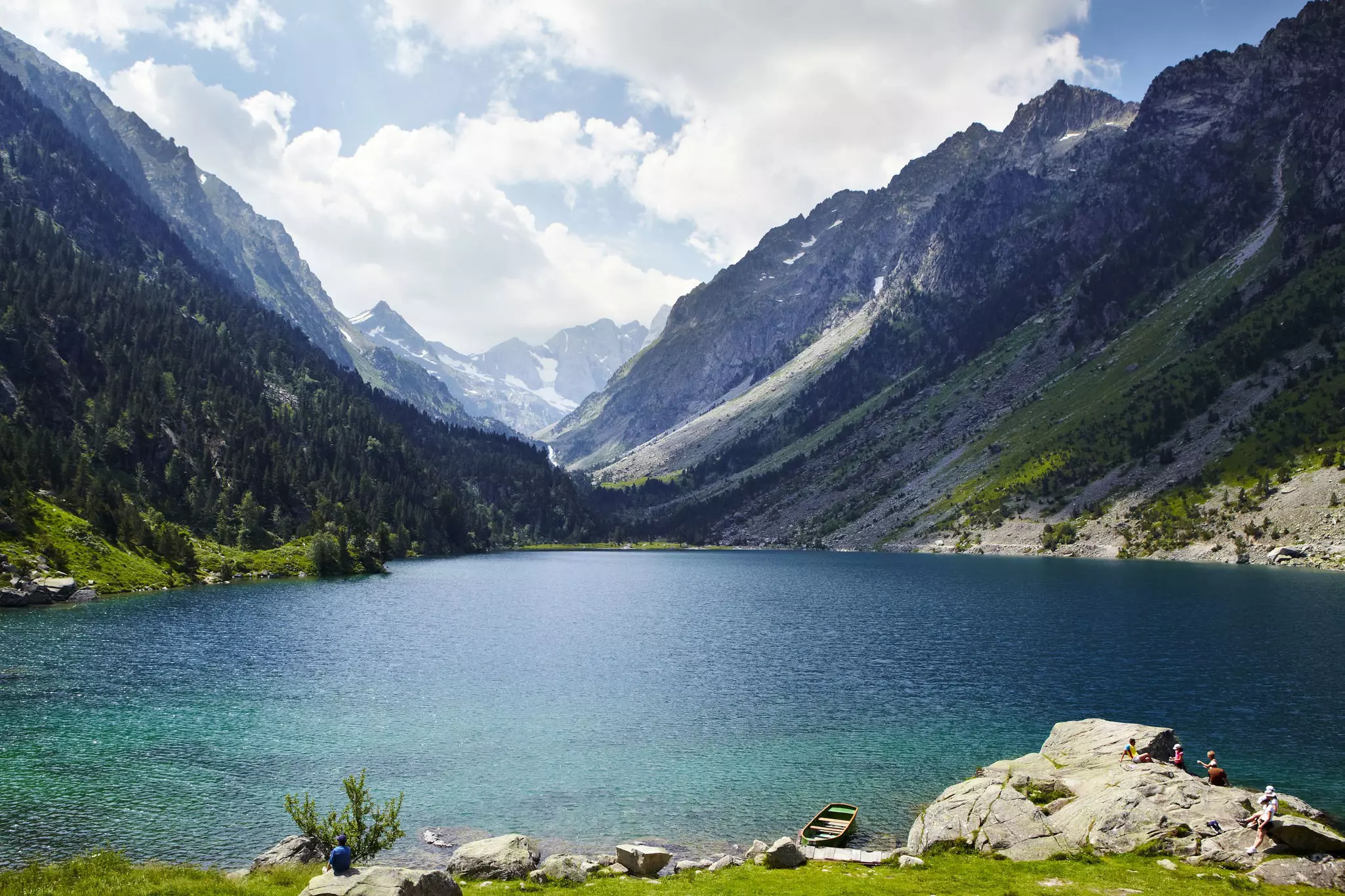 Hikers resting on a rock by a glacial lake on the Cirque de Gavarnie © Matt Munro / Lonely Planet