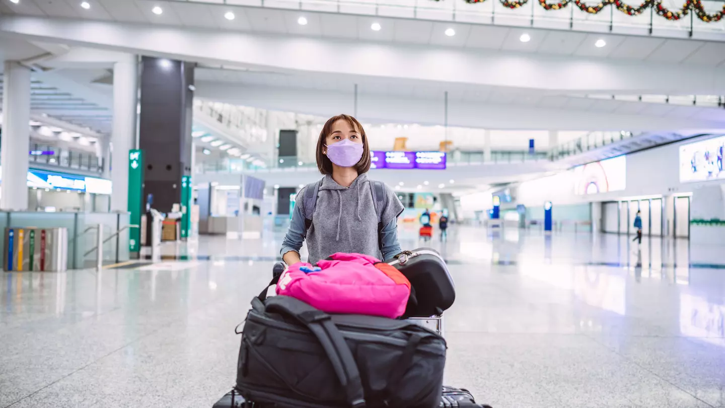 A young woman wearing a protective face mask in an airport