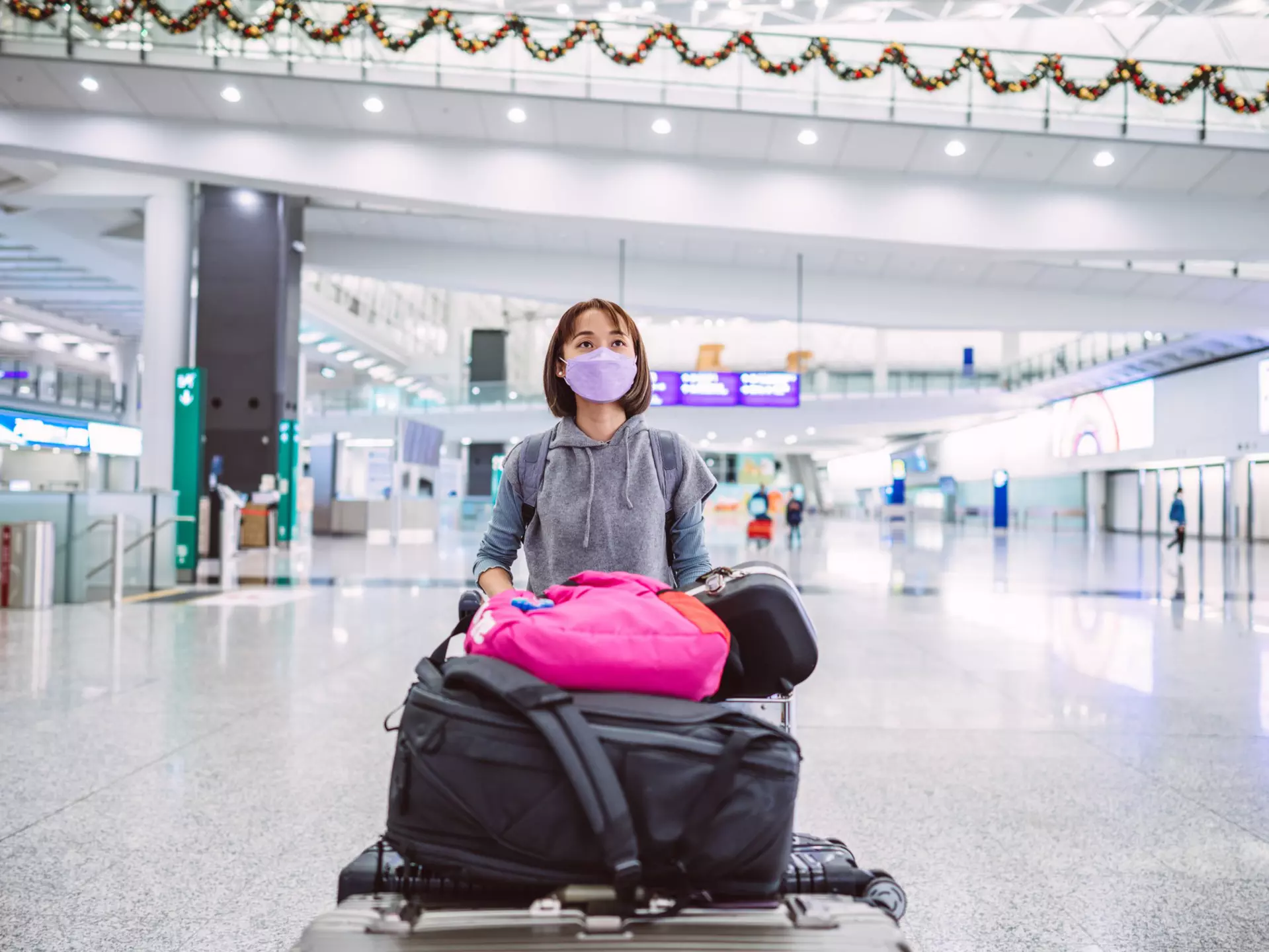 A young woman wearing a protective face mask in an airport