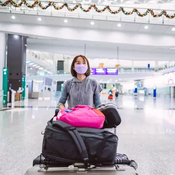 A young woman wearing a protective face mask in an airport