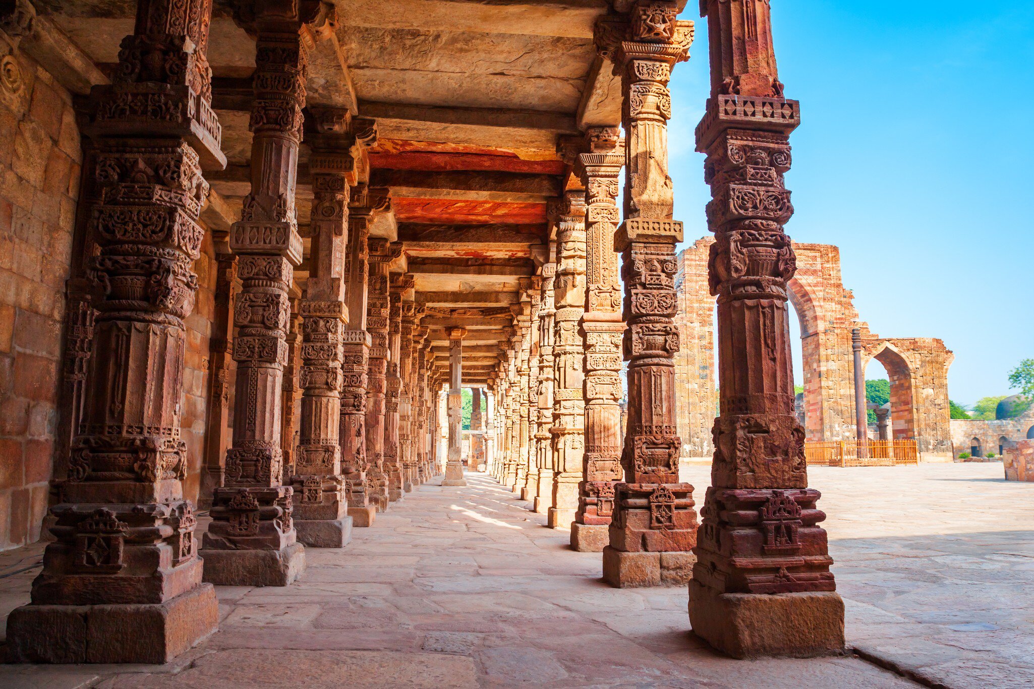View of intricately carved pillars and the courtyard of Quwwat-ul-Islam Mosque in the Qutb Minar complex in Delhi, India.