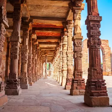 View of intricately carved pillars and the courtyard of Quwwat-ul-Islam Mosque in the Qutb Minar complex in Delhi, India.