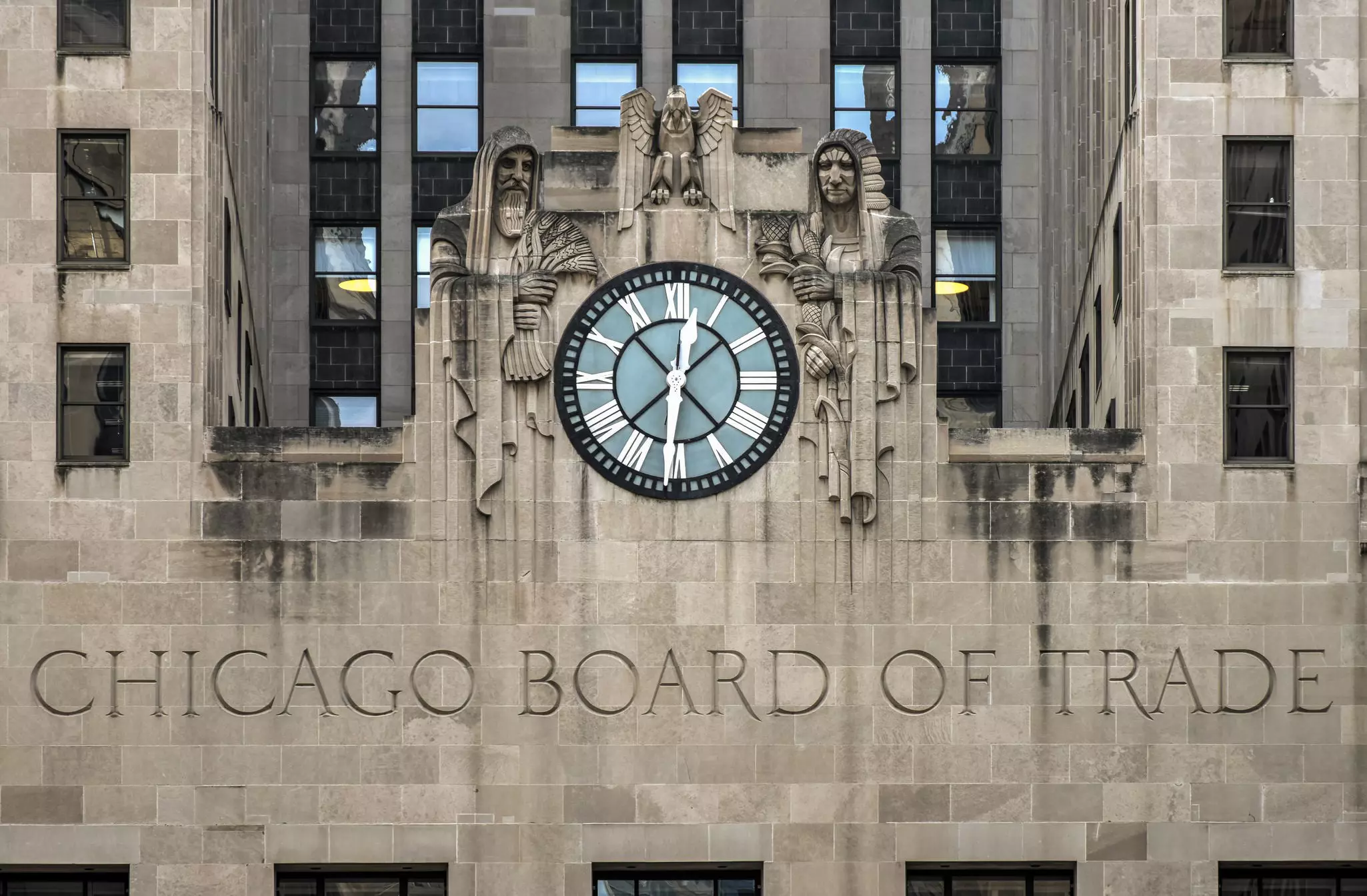 Facade of Chicago Board of Trade building, an art deco landmark, featuring a large clock and two carved figures