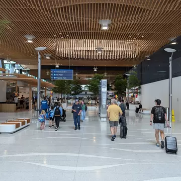 Passengers walk through an airport concourse with their luggage in Portland, Oregon, USA.