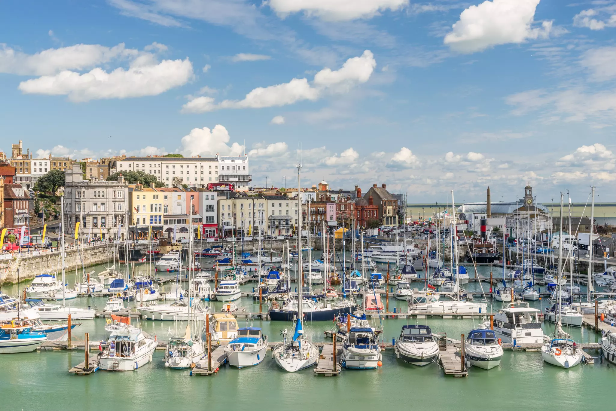 A pretty harbor docked with many small sail boats