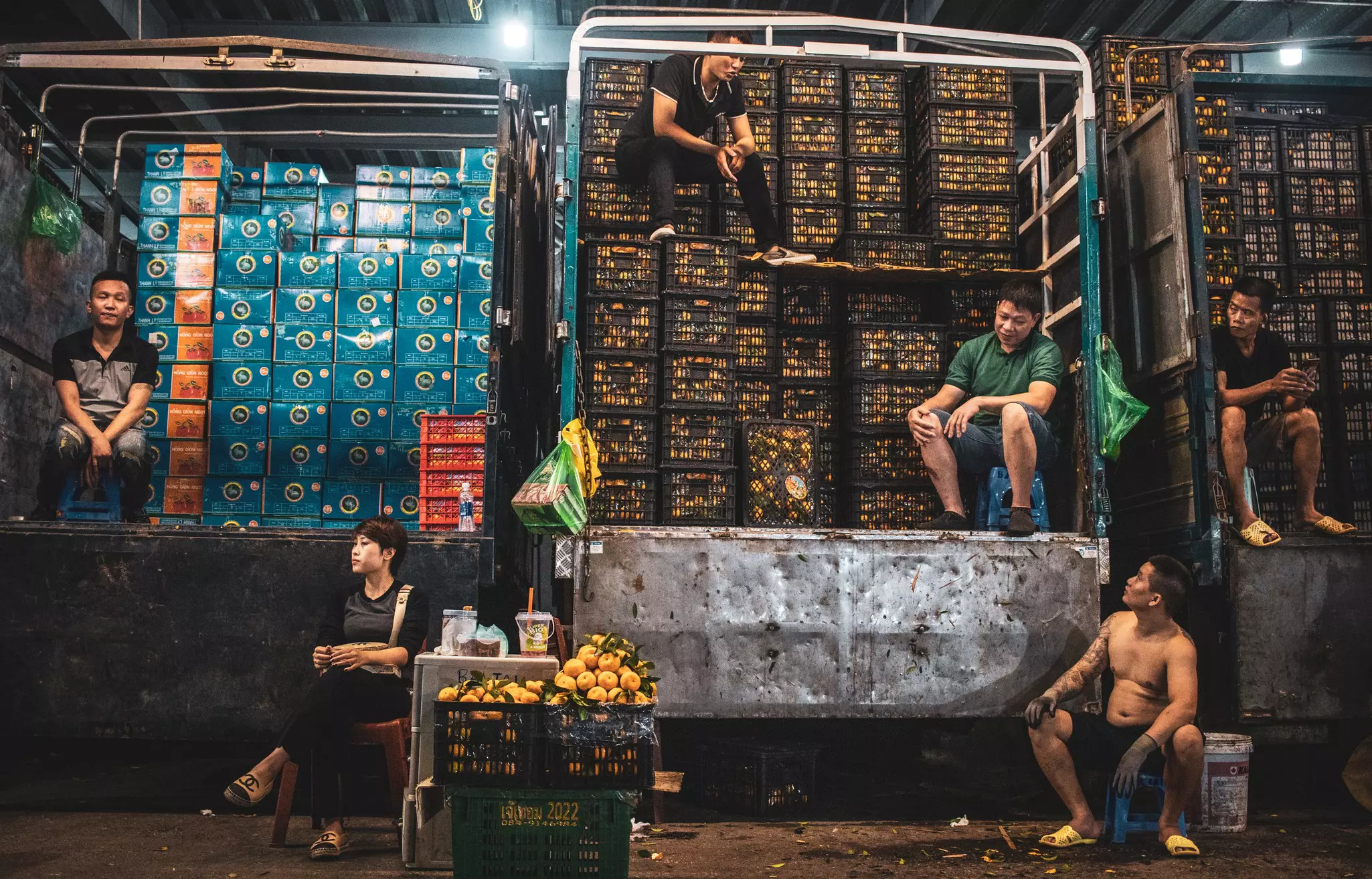 Traders sitting by their inventory at Long Bien market, Hanoi, Vietnam.
