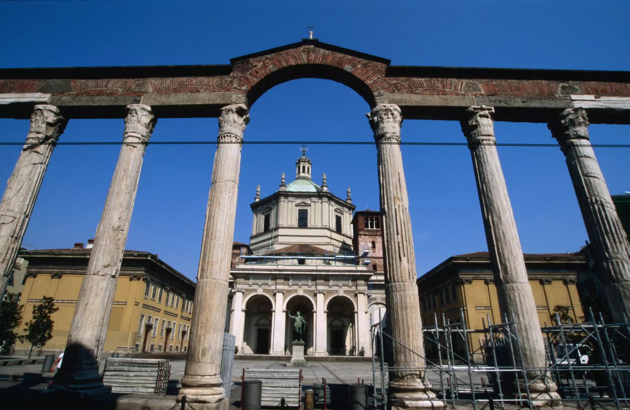 A church is framed by an archway with six visible columns.