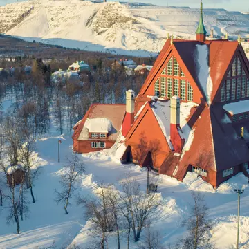 Kiruna Church from 1912, a landmark building built in wood in the town of Kiruna in the northern province of Lapland, Sweden. In the background is the iron mining operations in the town.
