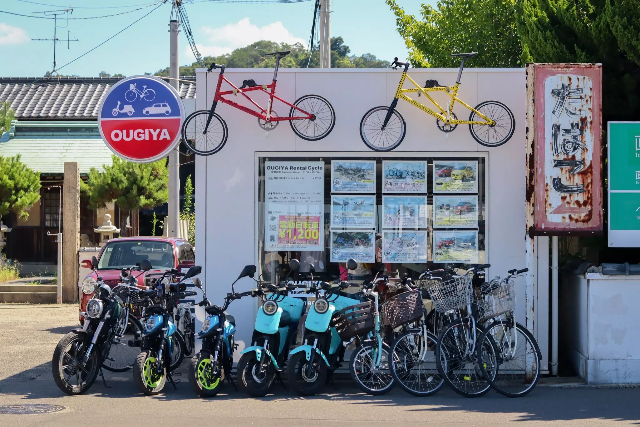 Bikes and scooters outside Ougiya rental shop across from the ferry terminal.