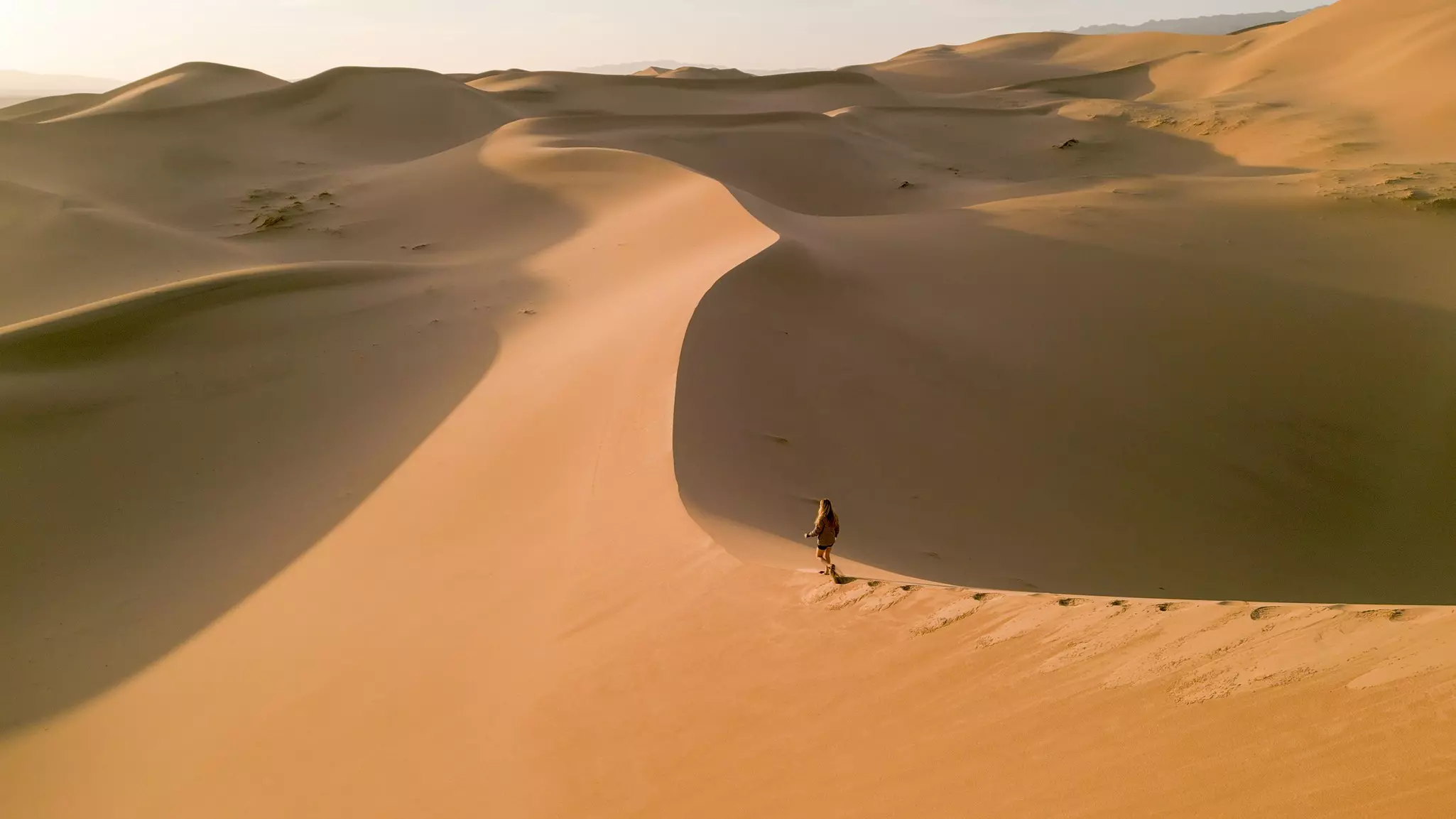 Greenberg walking on the singing sands of Khongoryn Els at sunrise © Jack Pearce/Lonely Planet