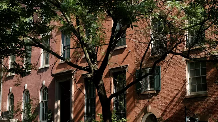 Brick facades of large row houses in the afternoon light.