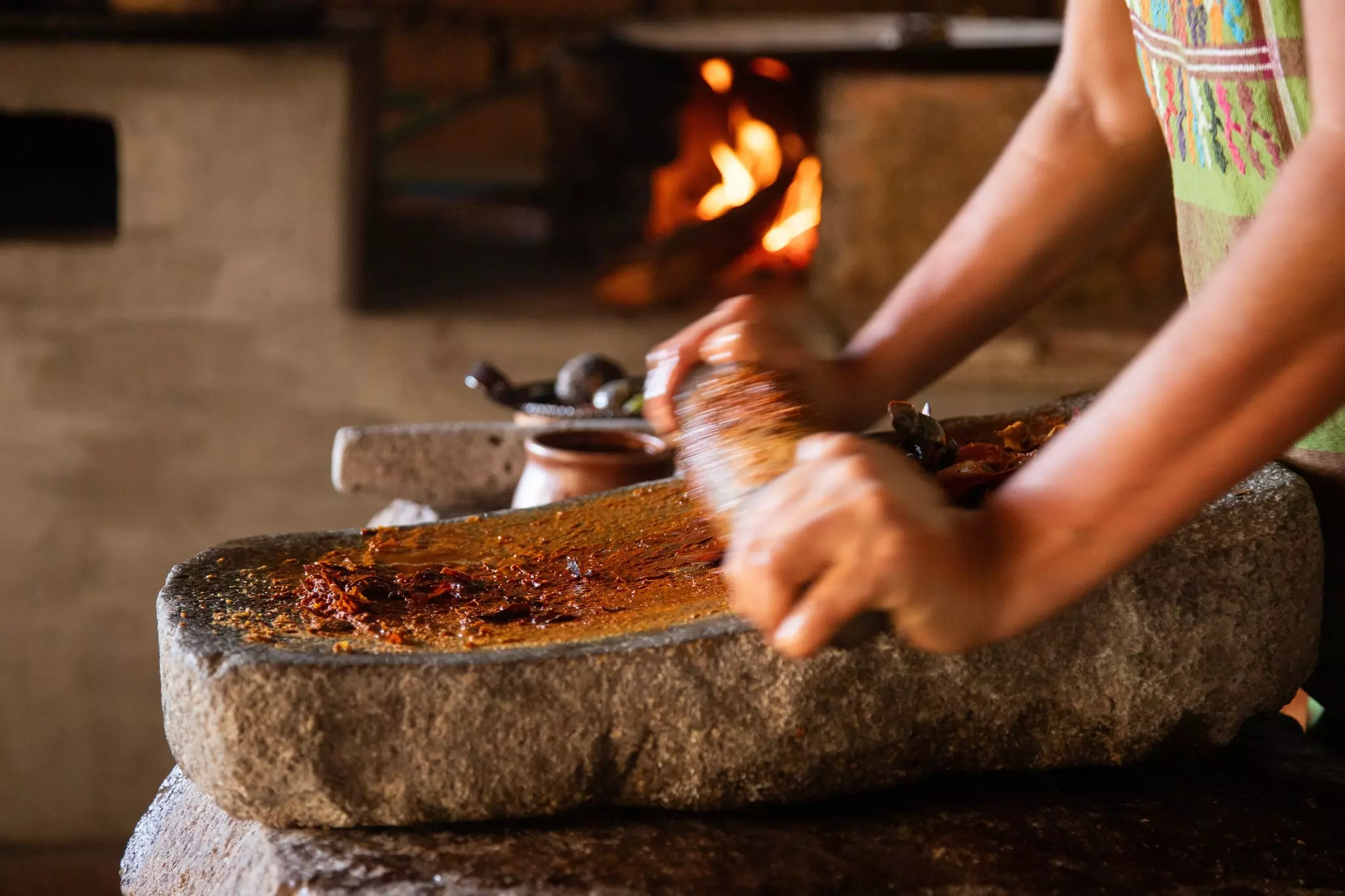 Woman from an indigenous community in Oaxaca preparing traditional red mole with a metate, a tool for grinding ingredients in Mexico., License Type: media, Download Time: 2025-10-27T15:45:10.000Z, User: katelyn.perry_lonelyplanet, Editorial: false, purchase_order: 65050 - Digital Destinations and Articles, job: wip, client: wip, other: Katelyn Perry