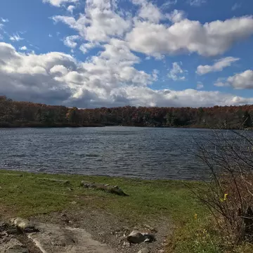 Crater Lake on the Appalachian  Trail in New Jersey Blue sky with clouds grassy shoreline with rocks and shrubs  License Type: media  Download Time: 2021-09-22T16:59:05.000Z  User: Malecia.Elamin_Lonelyplanet  Is Editorial: No  purchase_order: