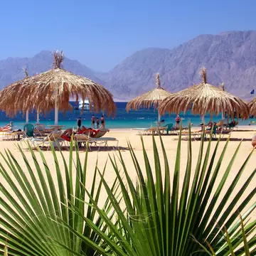 People bask on a sandy beach on the Red Sea Coast of Egypt. Beneda Miroslav/Shutterstock