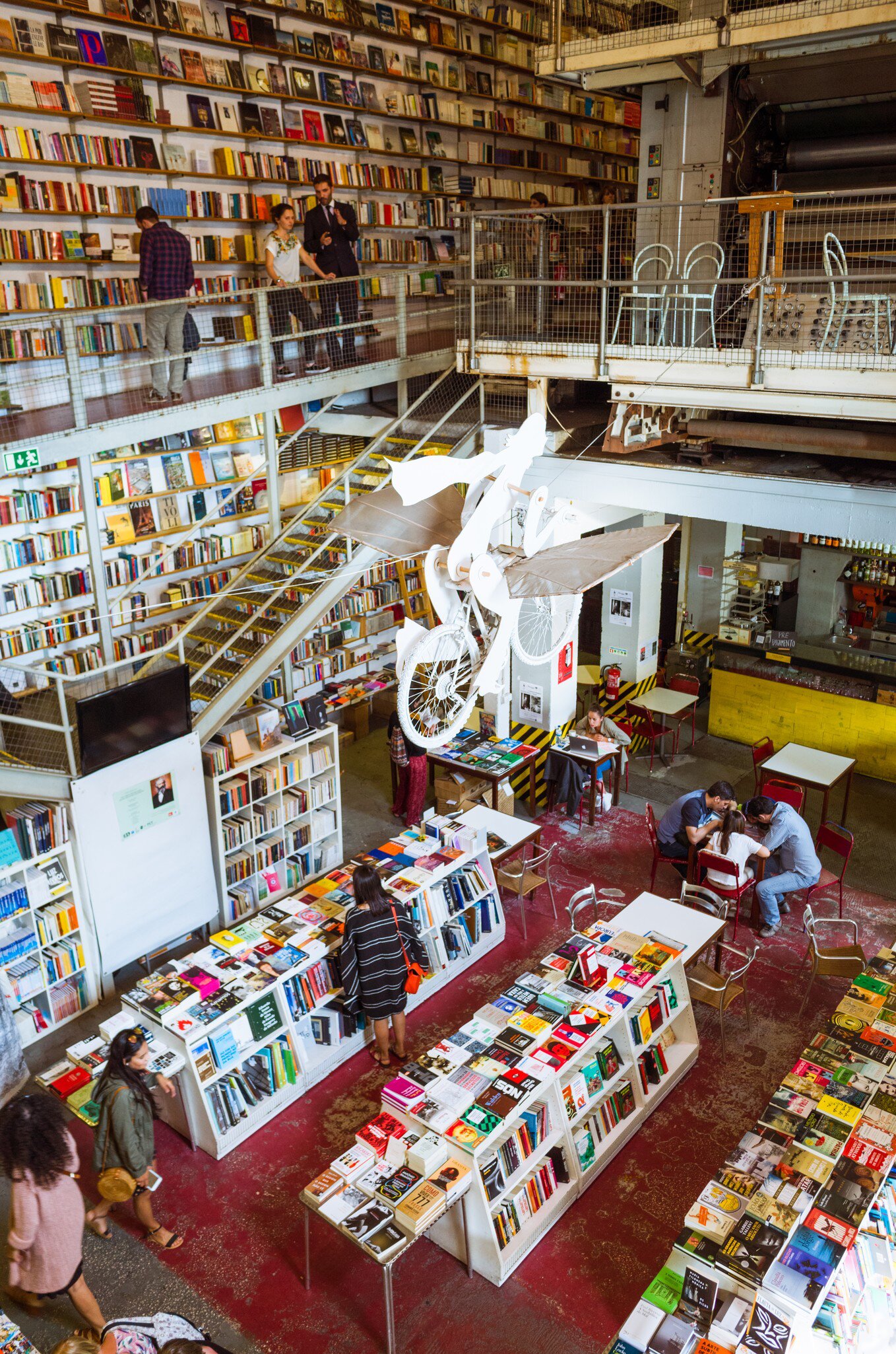 People reading and browsing through the bookstore within the LX factory creative hub complex in Lisbon, Portugal.