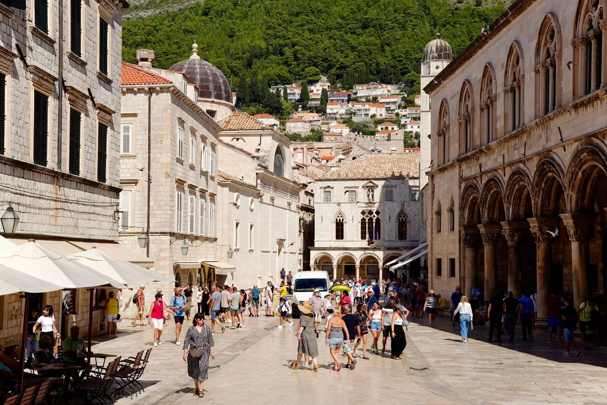 People promenade along cafe-lined Stradun in Dubrovnik, Croatia.