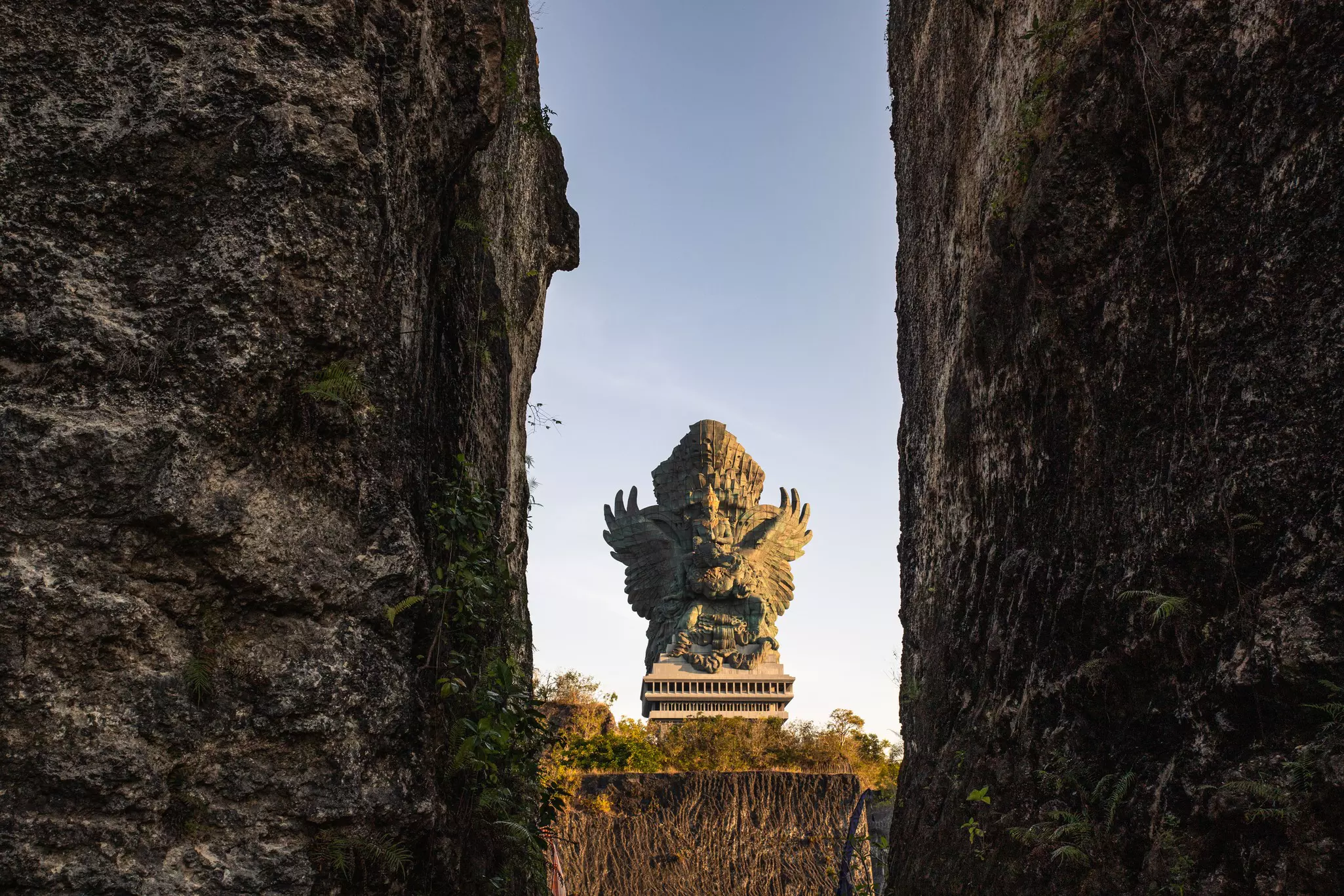 Looking between two rocks at a large statue