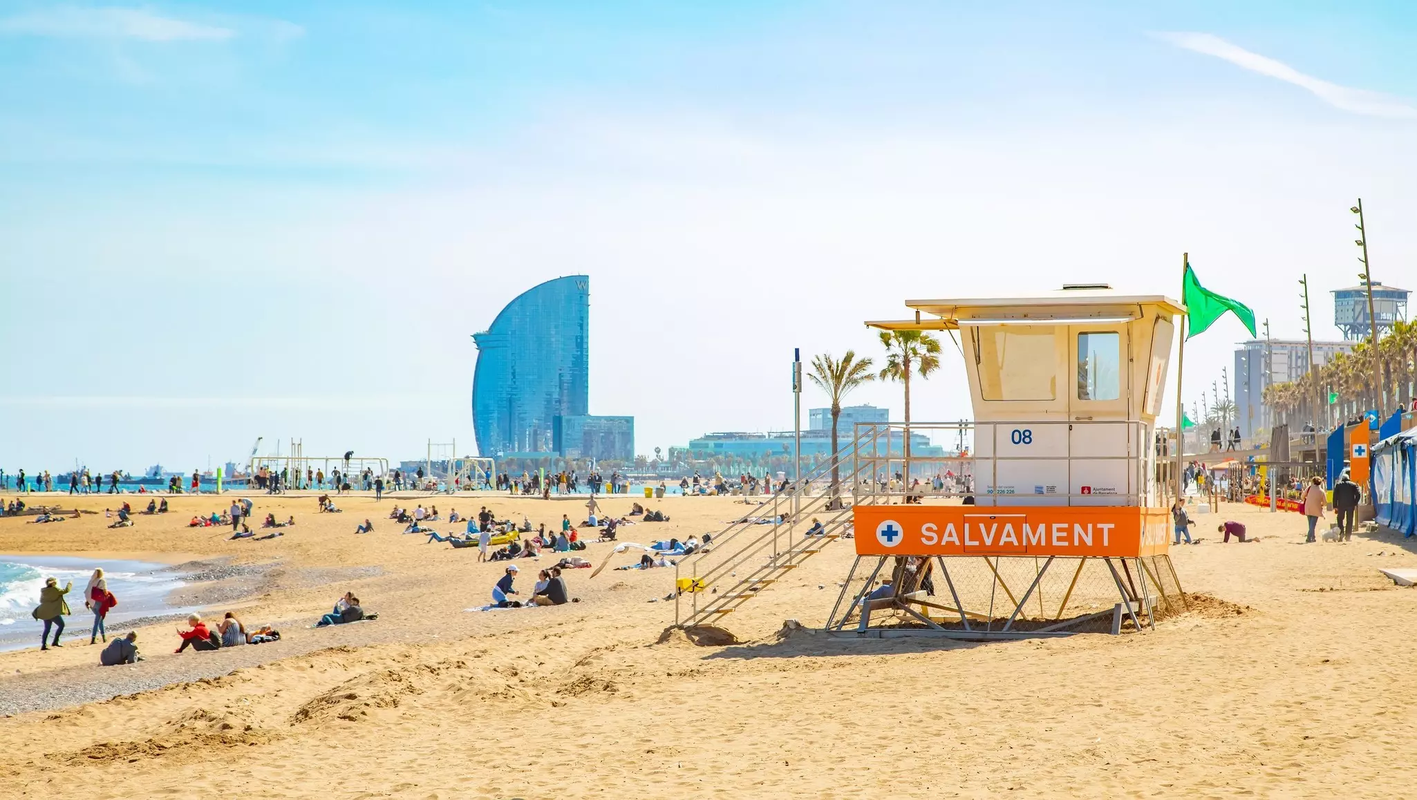 Beachgoers and a lifeguard hut on Barceloneta beach in Barcelona. 