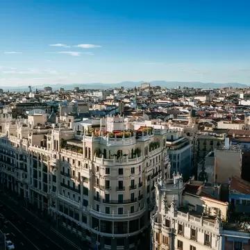 Gran Vía lined with ornate early 20th-century buildings and the Metropolis dome, seen from above, Madrid.