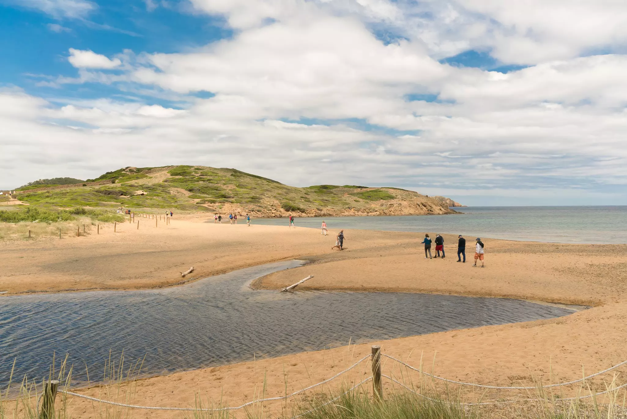 Tourist are walking through the Camí de Cavalls (Horse Road) of Menorca. It is a historic heritage and declared of cultural interest in the Balearic Islands. Spain
