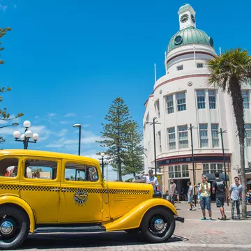 Napier, New Zealand -December-30-2017 : The classic cars tour parked in front of T&G building an iconic art deco landmark building in Napier town, New Zealand.