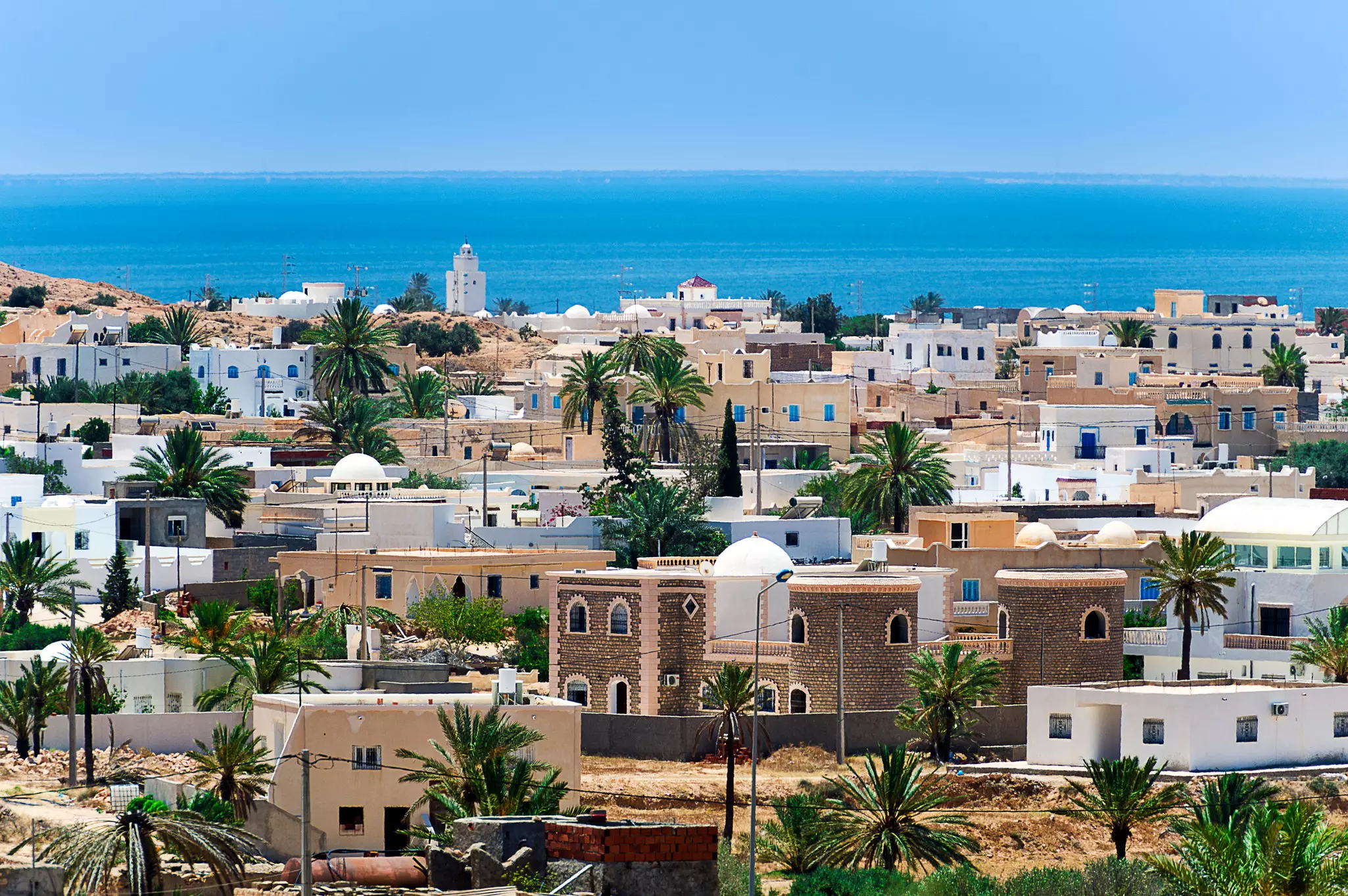 A view of a town with white and beige buildings by the ocean