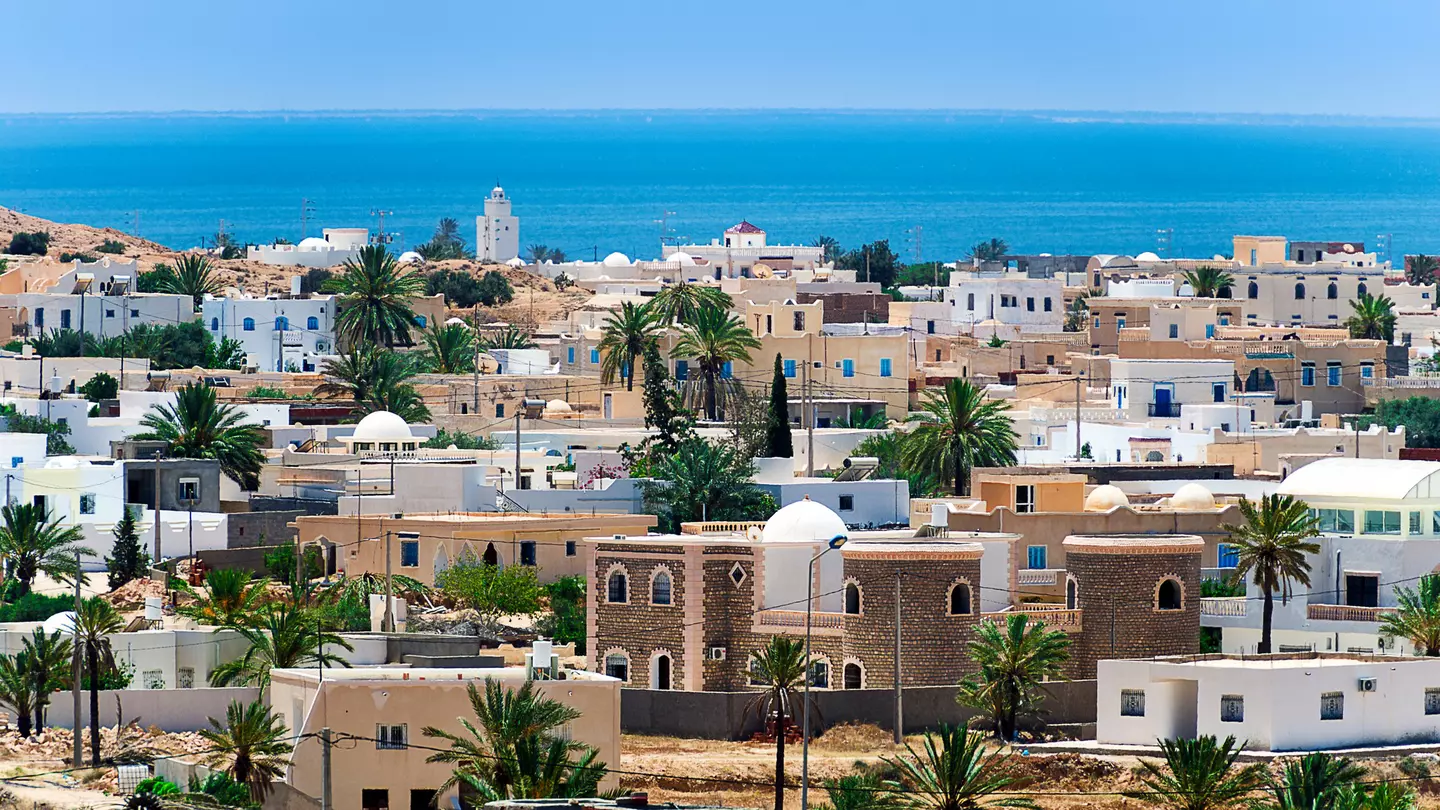 A view of a town with white and beige buildings by the ocean