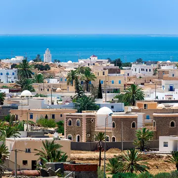 A view of a town with white and beige buildings by the ocean