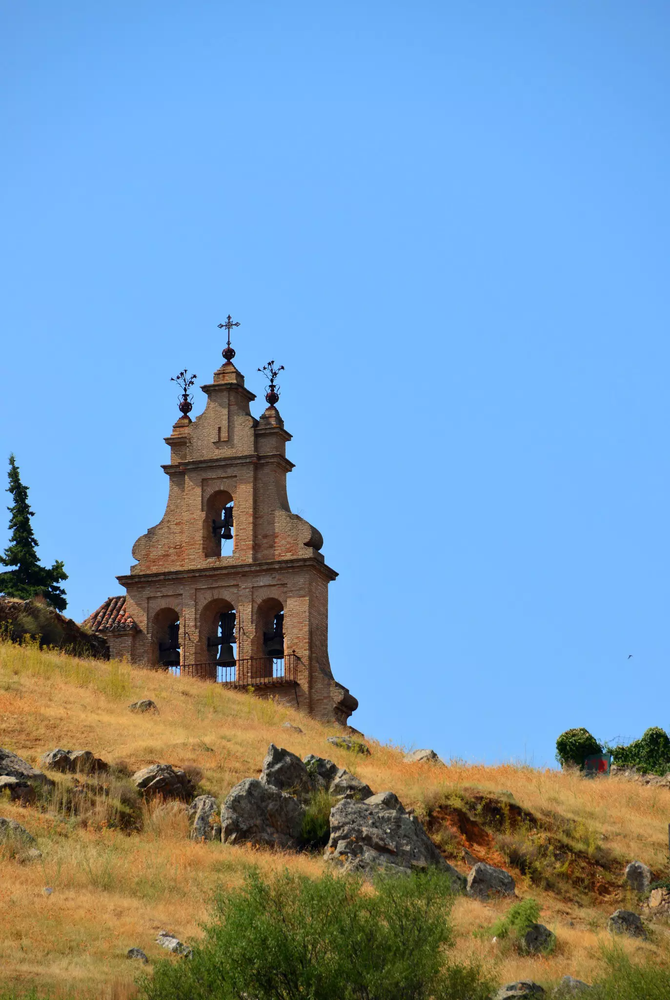 Aracena, Andalucía, Spain: Bell-gable of the Priory Church seen against the sky - church built by the Knights Templar Order in Moorish-style - Iglesia Prioral de Nuestra Señora del Mayor Dolor o del Castillo, Hermanad de la Vera Cruz, espadaña