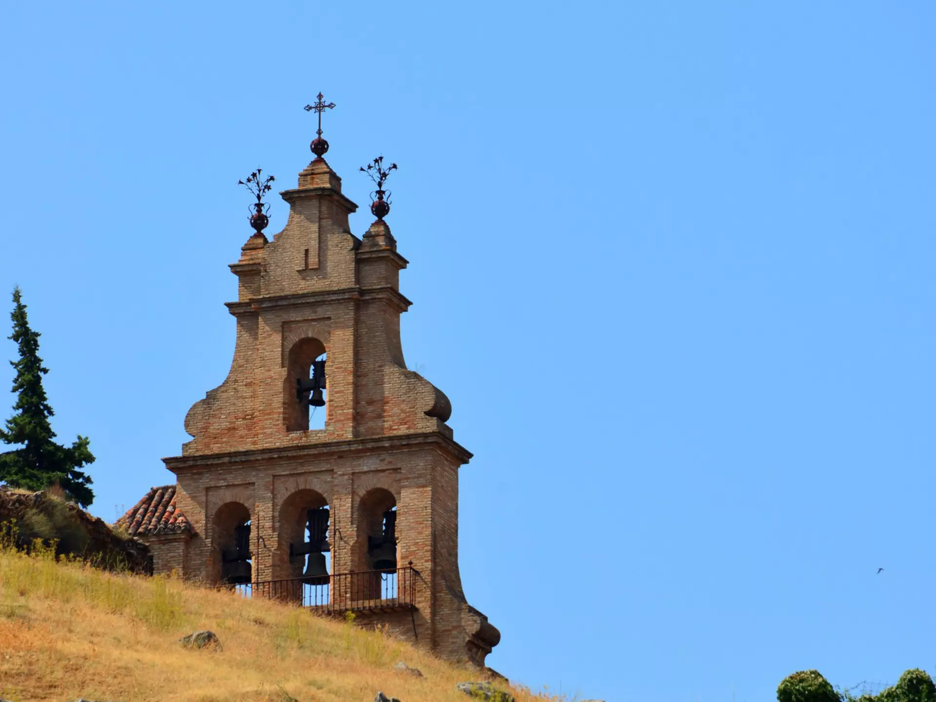 Aracena, Andalucía, Spain: Bell-gable of the Priory Church seen against the sky - church built by the Knights Templar Order in Moorish-style - Iglesia Prioral de Nuestra Señora del Mayor Dolor o del Castillo, Hermanad de la Vera Cruz, espadaña