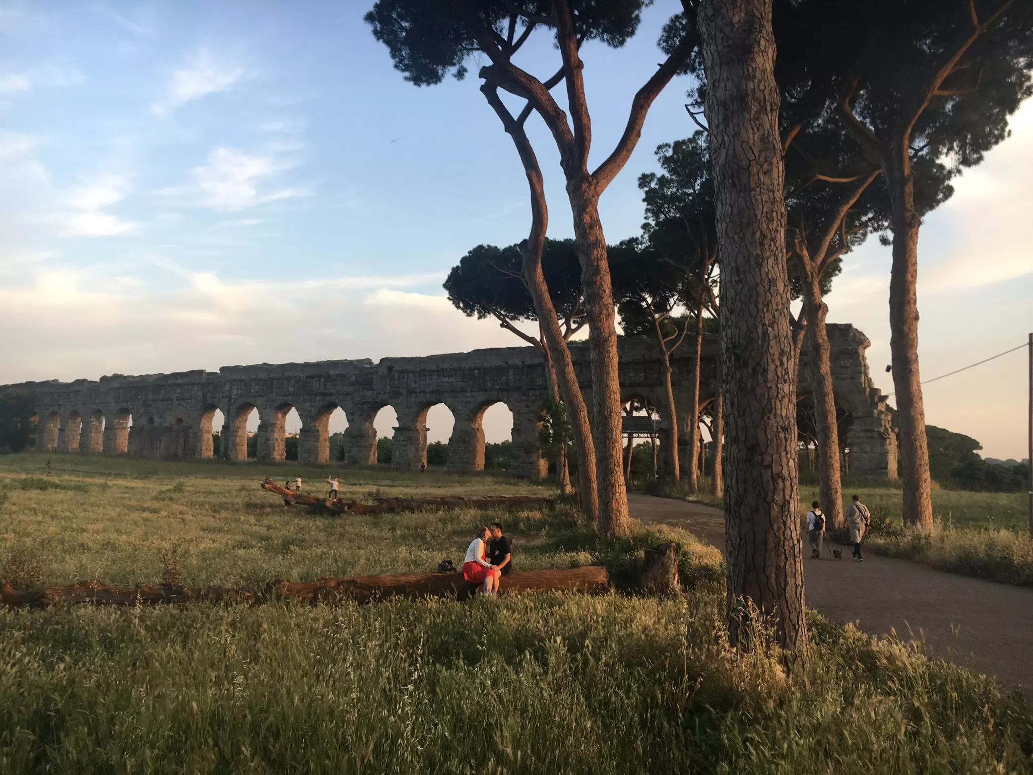 People walking in the Parco degli Acquedotti at sunset, Rome. 