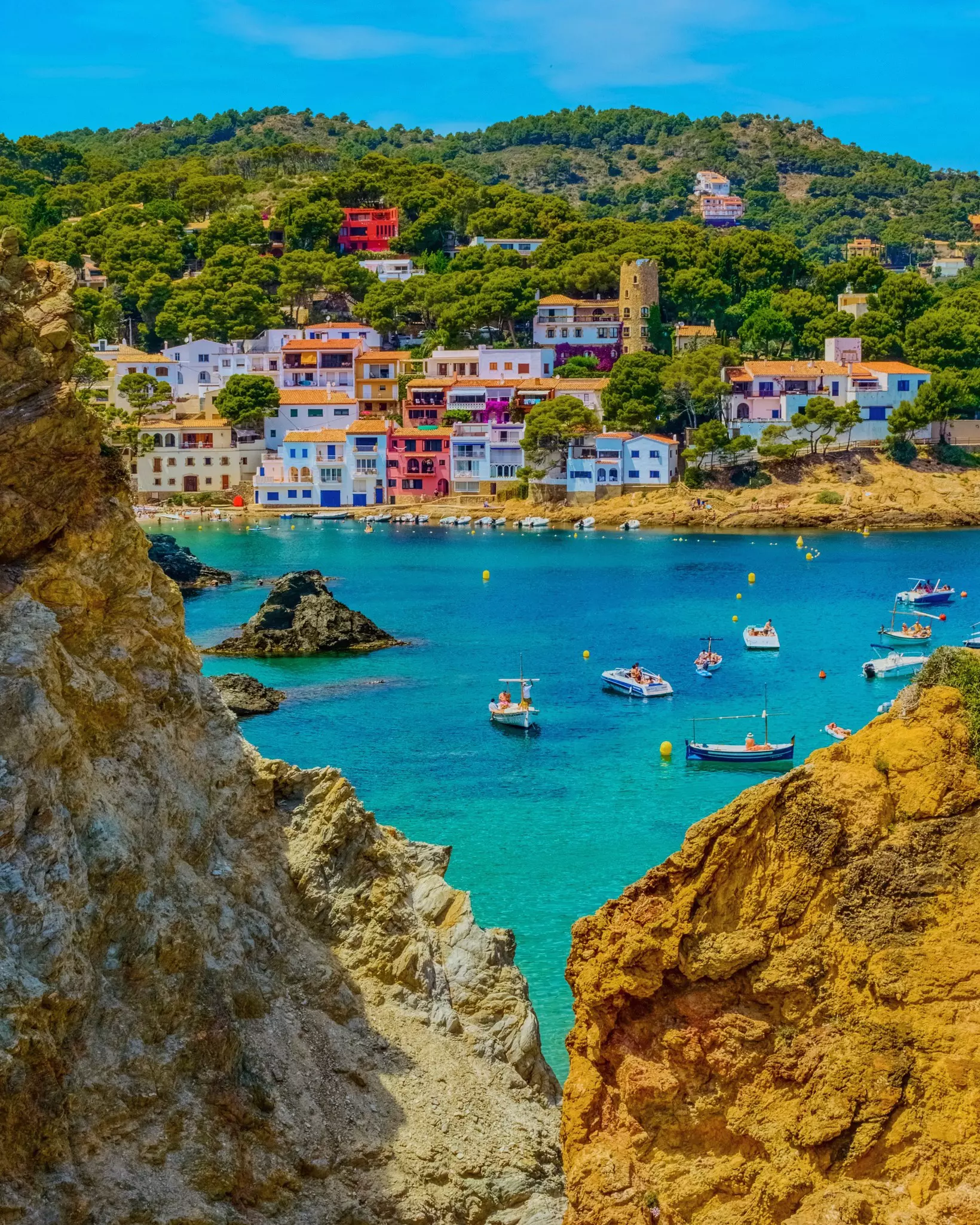 A small cove backed by apartment buildings set into cliffs along Costa Brava