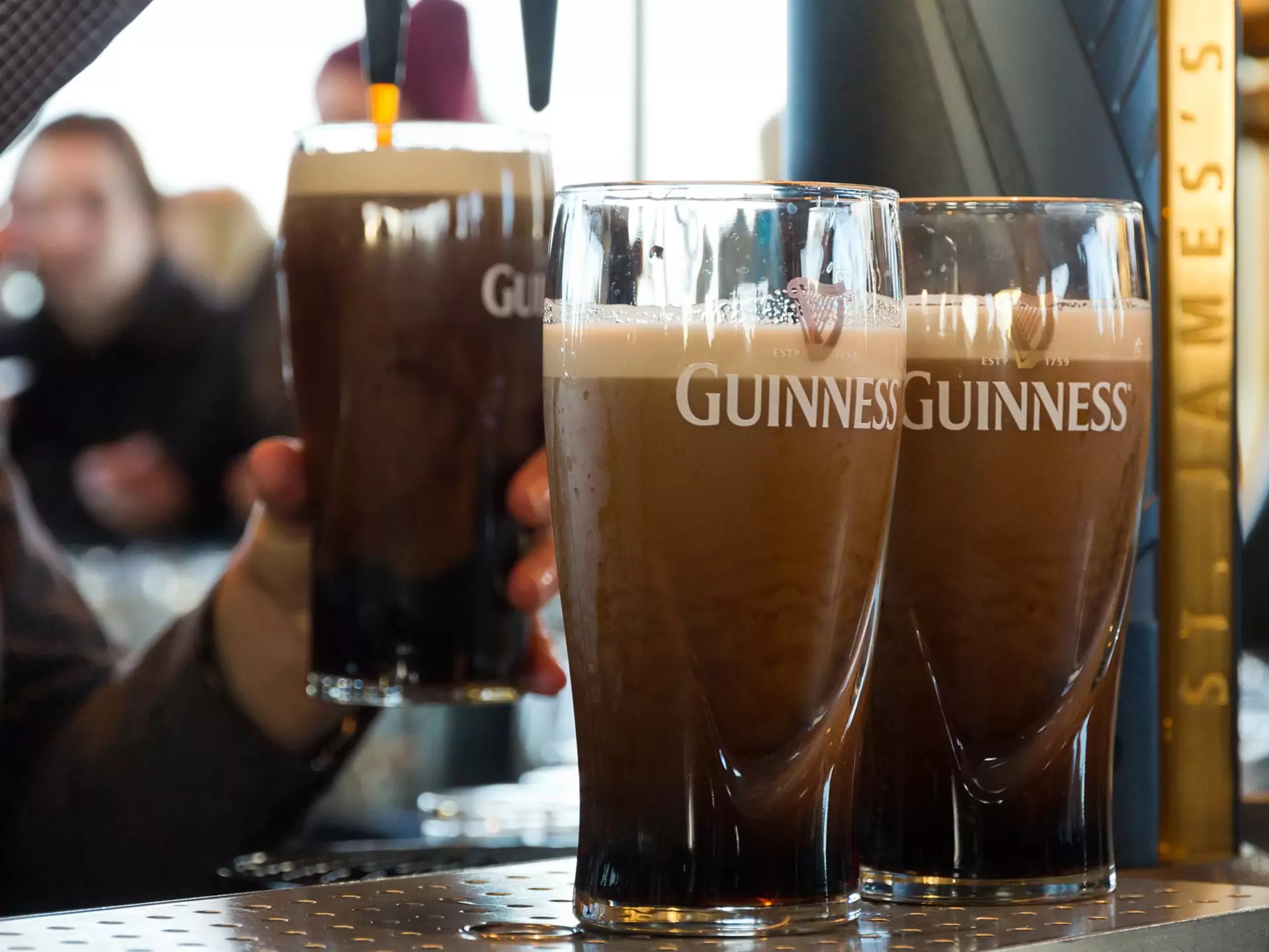 Four pints of half drunk Guinness on the counter in an Irish pub