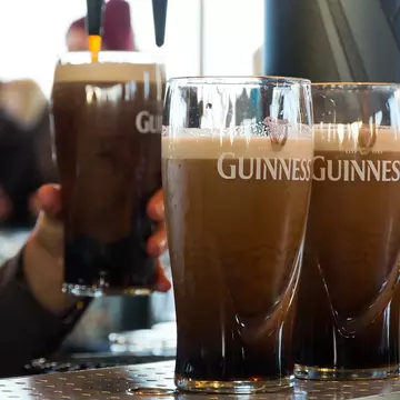 Four pints of half drunk Guinness on the counter in an Irish pub