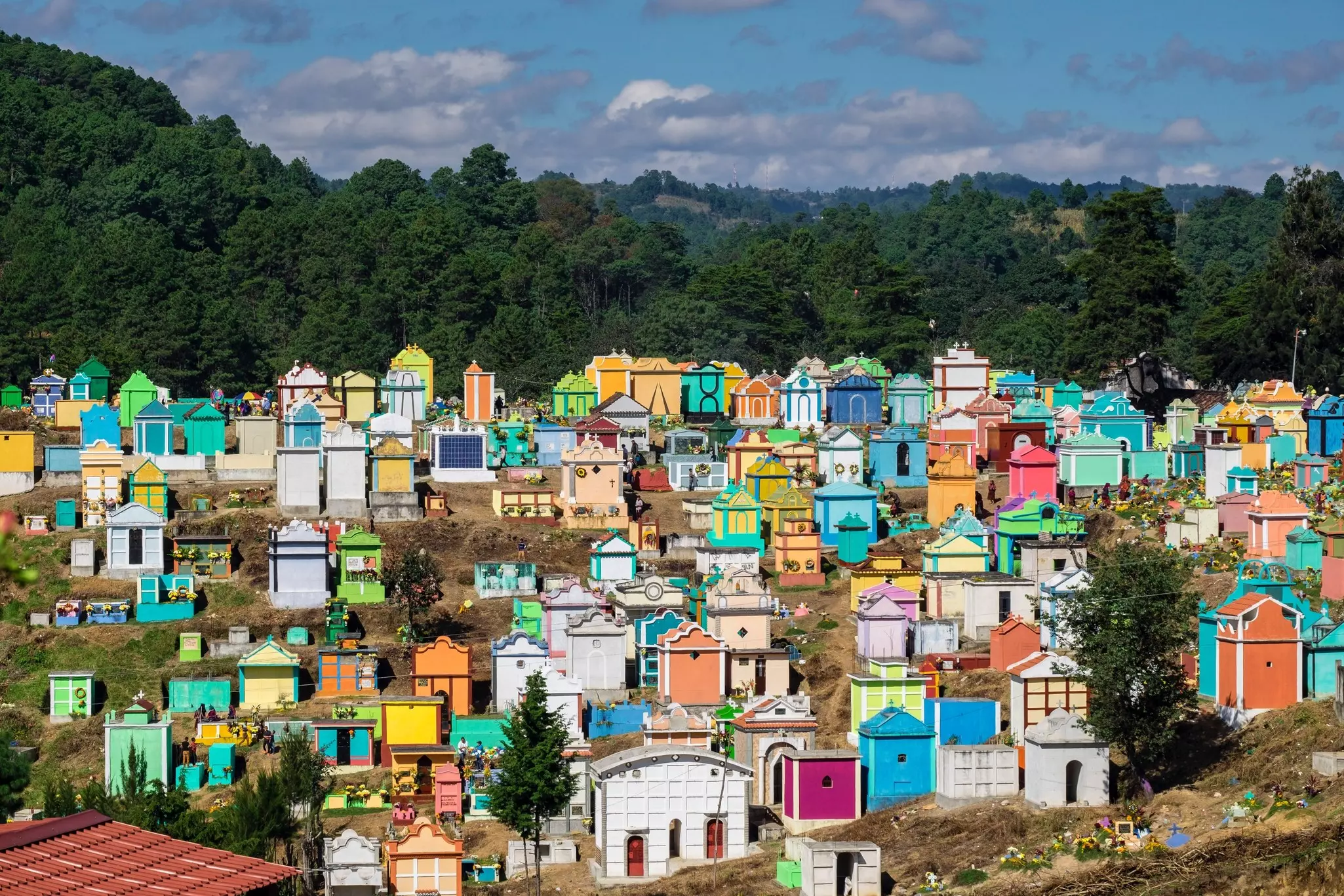 A hillside covered in grave markers of bright colors in Chichicastenango Cemetery, Guatemala