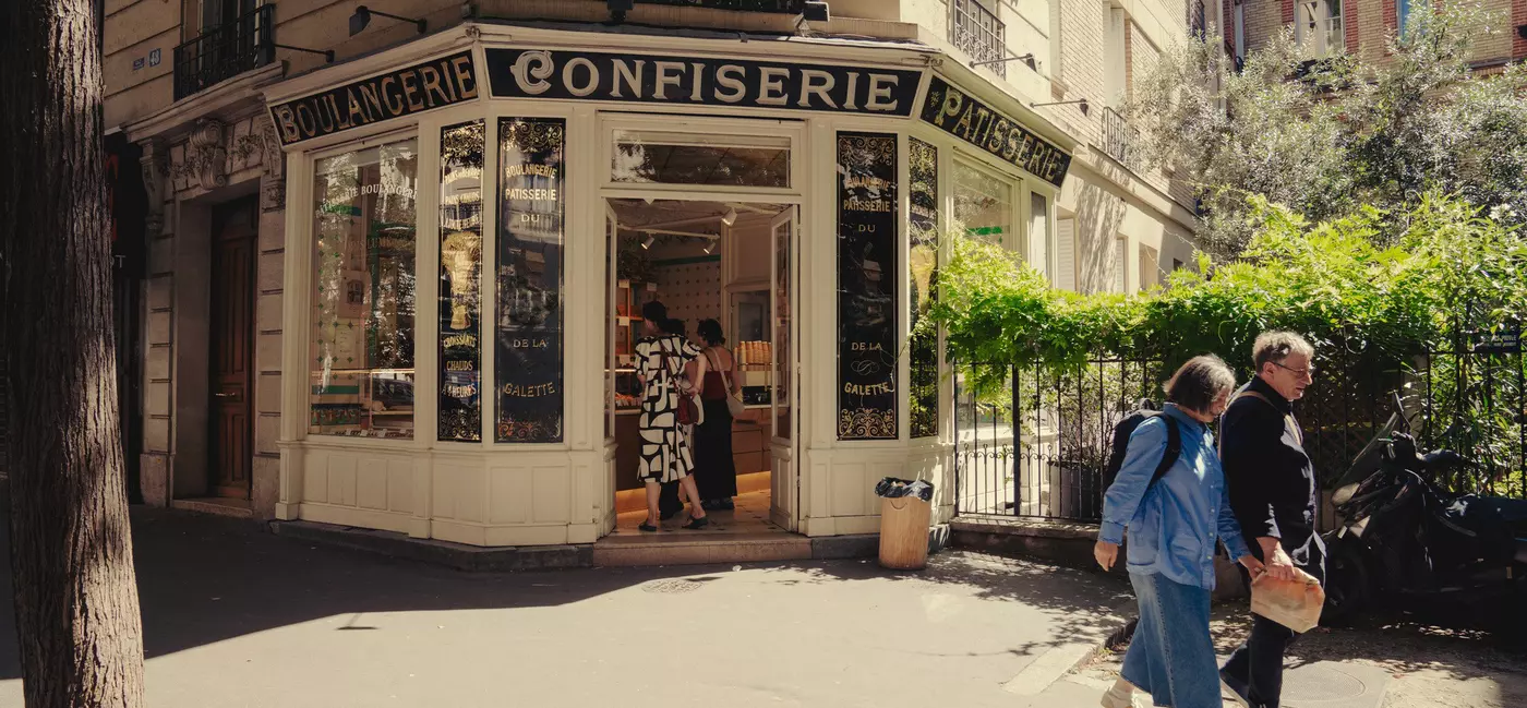 A couple passes a shop in Montmartre and Northern Paris, Rue Caulaincourt, Paris, France. 
