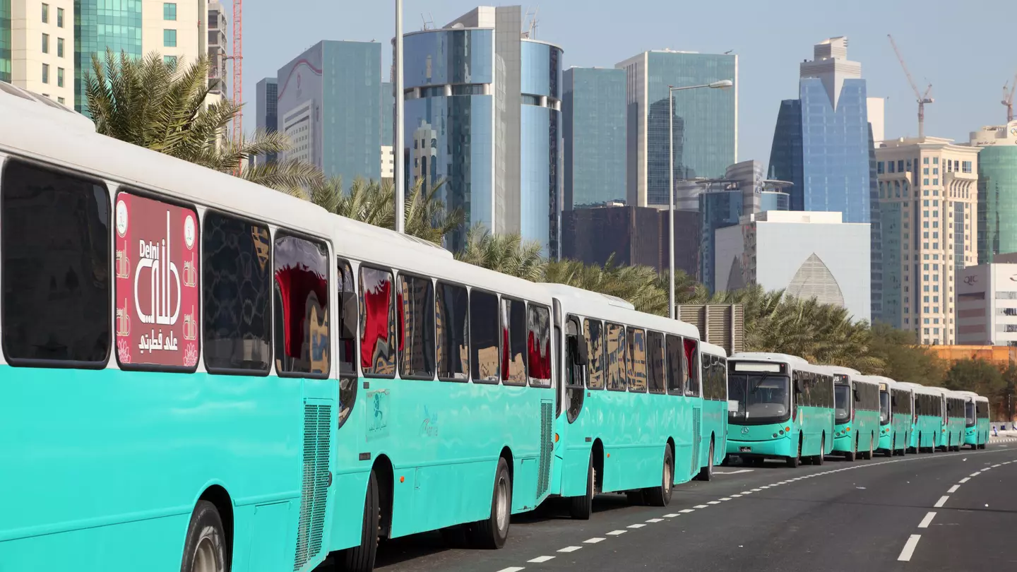 A line of turquoise buses line up along the Corniche of Doha at the Qatar National Day