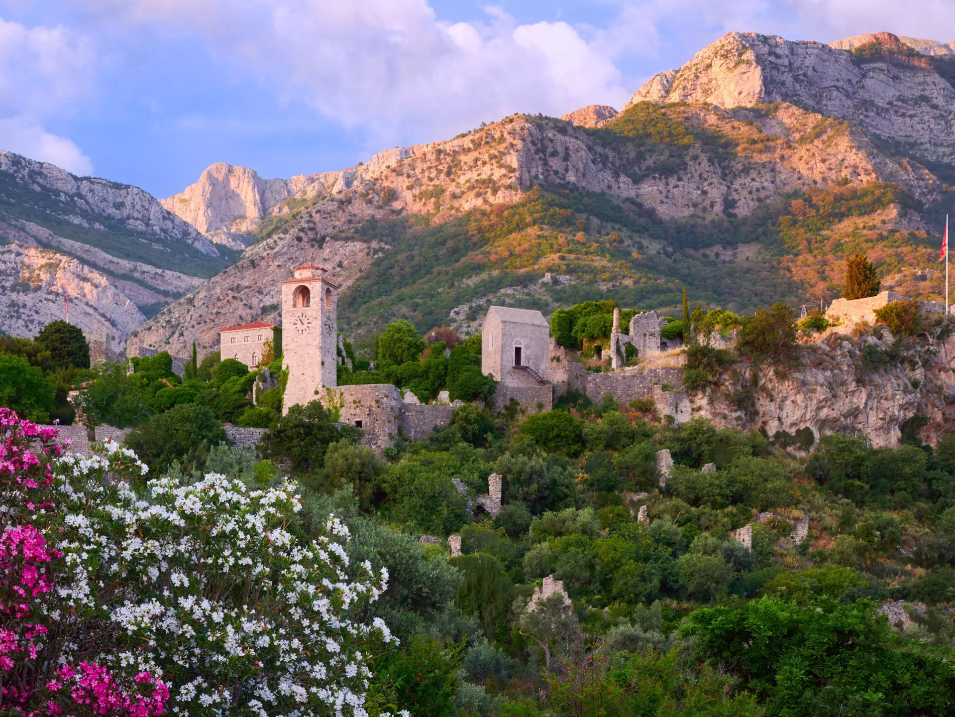 View of Old town in Stari Bar in Montenegro looking up the mountain with a pink dusk sky behind