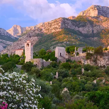 View of Old town in Stari Bar in Montenegro looking up the mountain with a pink dusk sky behind
