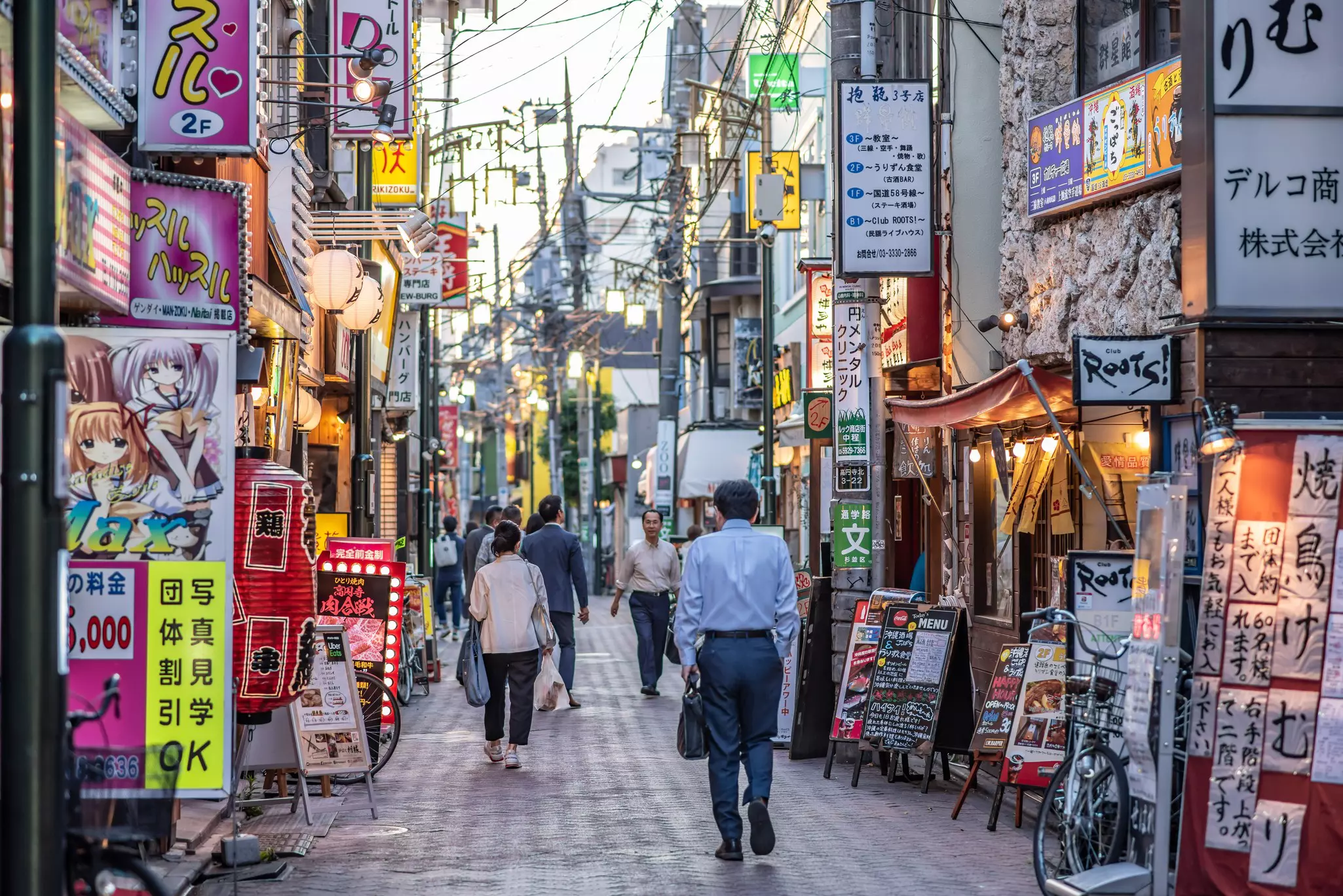 A pedestrian shopping street with a lot of Japanese signage outside shops