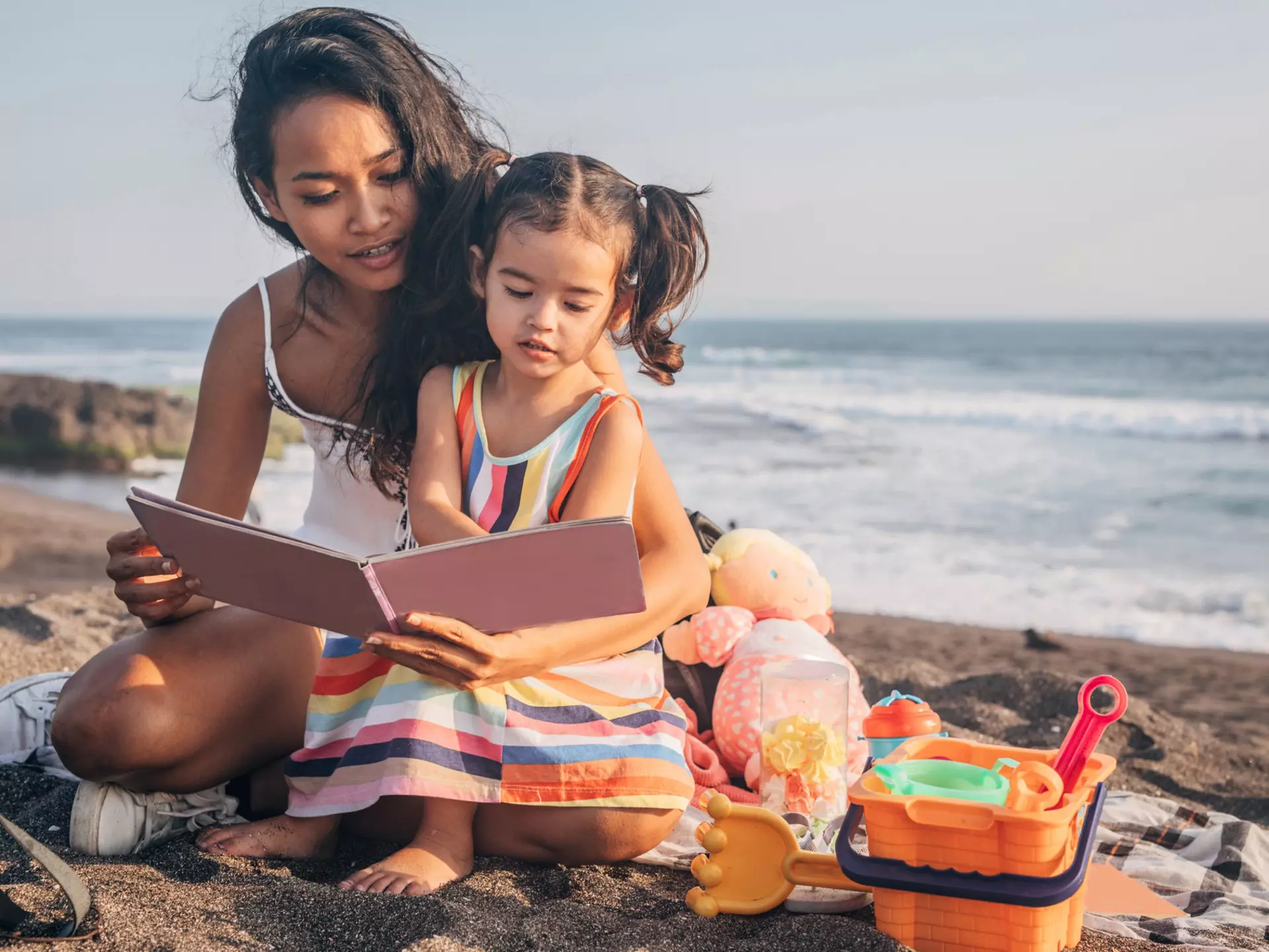 Two people, mother and daughter relaxing on the beach.
1168158535
human, person, people, reading, family, female, girl