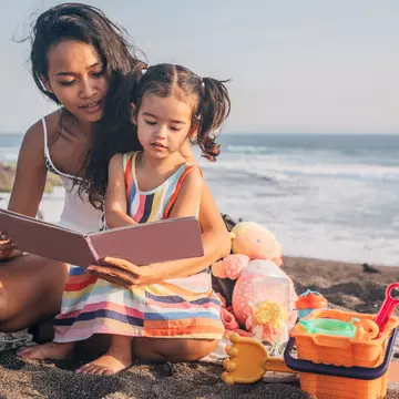 Two people, mother and daughter relaxing on the beach.
1168158535
human, person, people, reading, family, female, girl