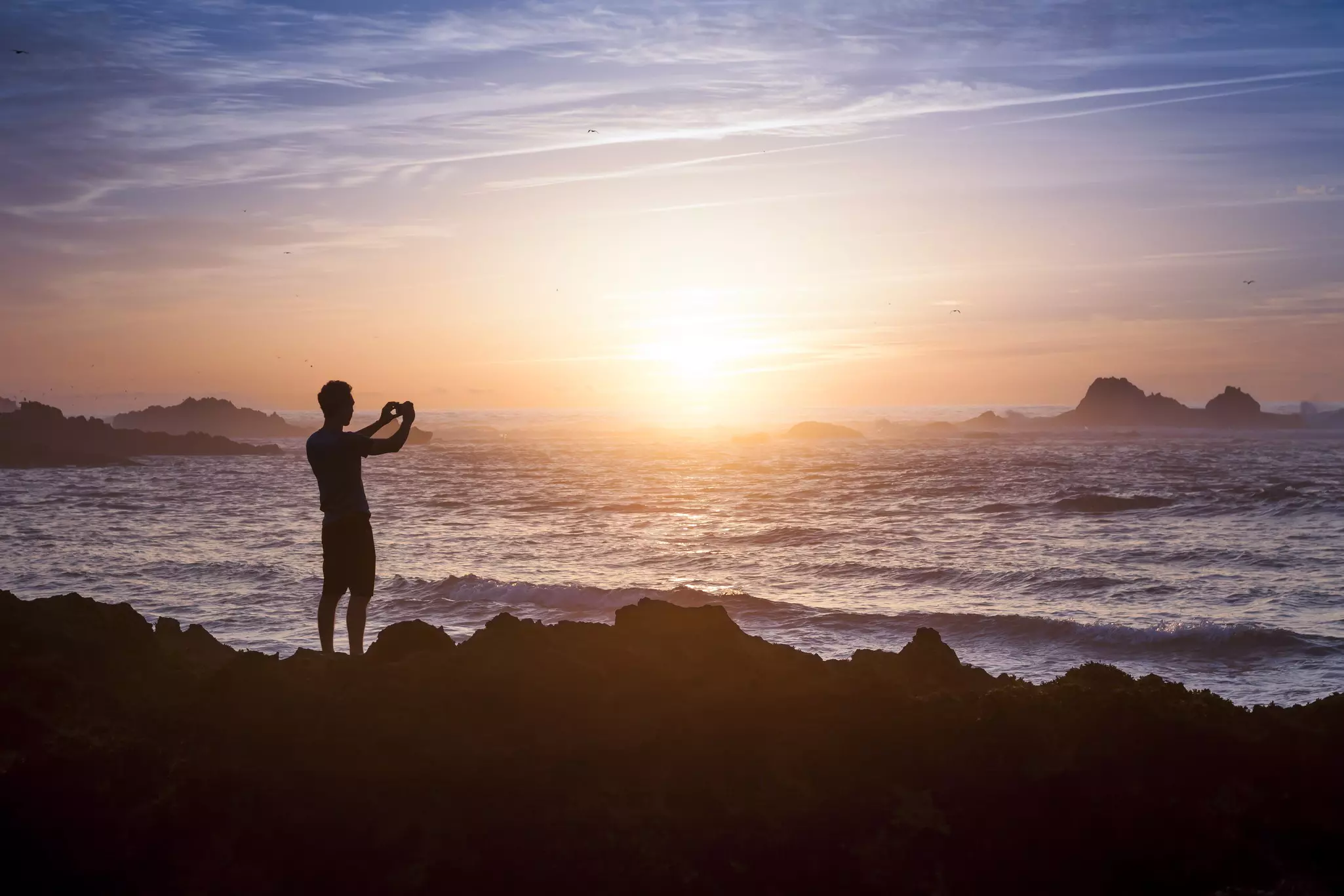 Young adult taking photo of amazing sunset light on the beach, License Type: media, Download Time: 2025-03-11T10:15:54.000Z, User: joebindloss38, Editorial: false, purchase_order: 65050 - Digital Destinations and Articles, job: Online Editorial, client: How to get your cell phone connected in Morocco: eSIMs, wi-fi and mobile networks, other: Joe Bindloss