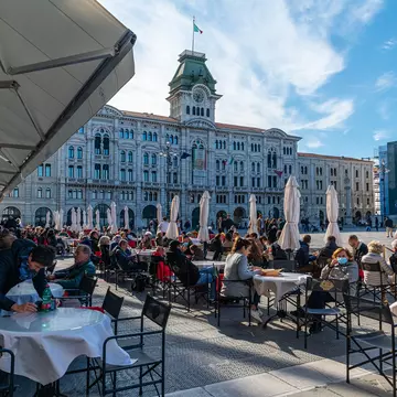 Trieste, Italy 16.10.2021: People enjoyin coffee at famous coffeeshop at the Piazza dell’Unità d’Italia, the main square in Trieste on sunny october day; Shutterstock ID 2062626323;