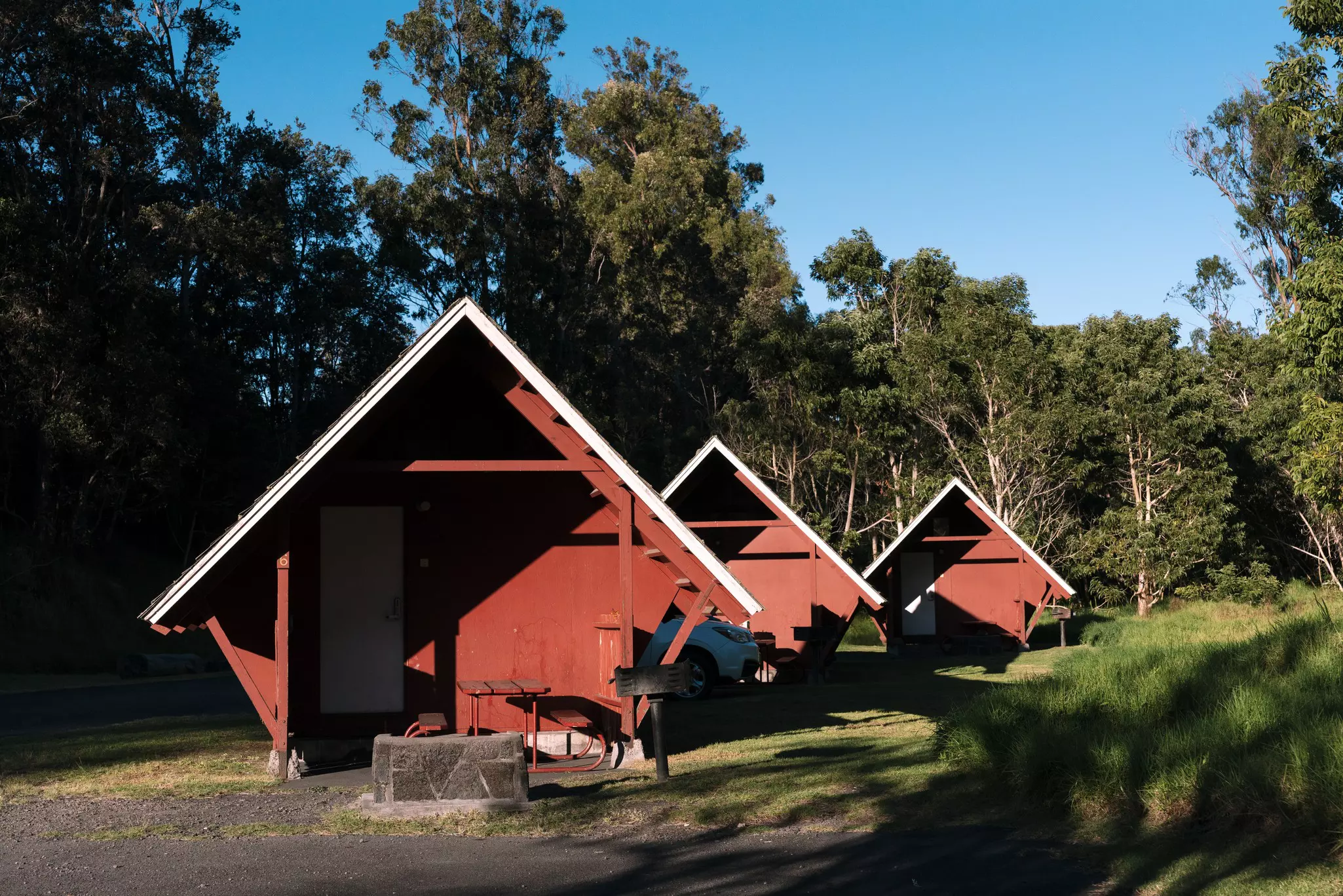 Three small red A-frame cabins