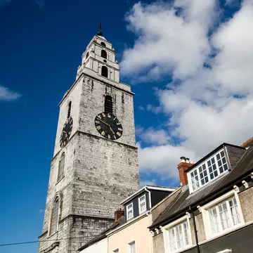 Clock tower at Church of St. Anne in County Cork, Ireland.  Low angle with blue sky in background.