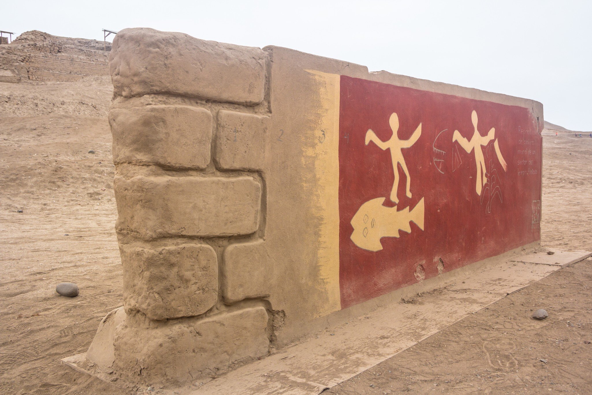 Pachacamac archeological site with original painting on a stone wall outside of Lima, Peru.