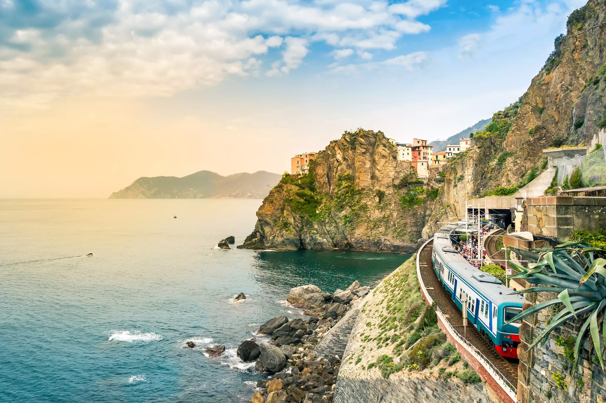 A train at a seaside station in Italy's Cinque Terre with colorful cliffside houses